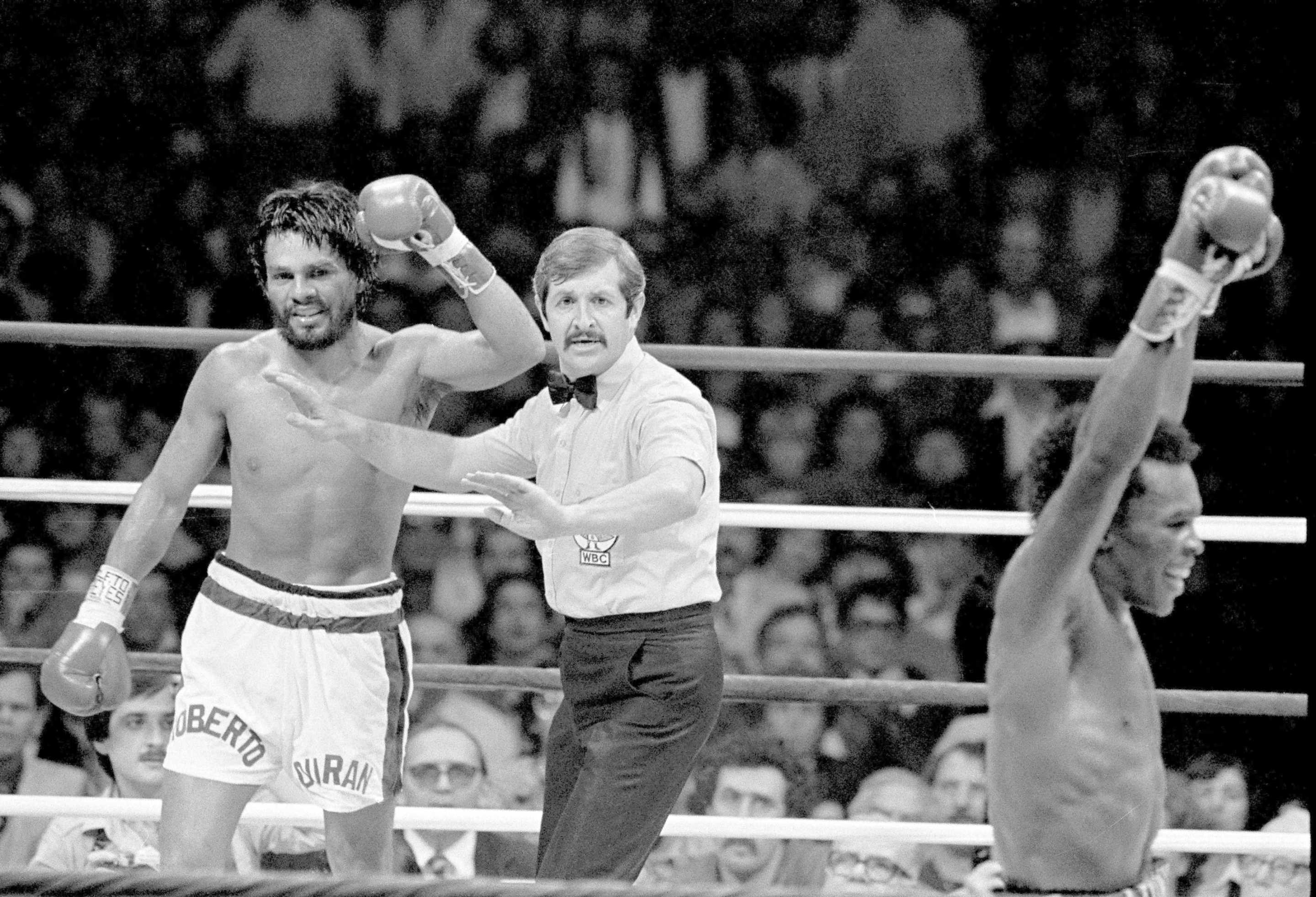 Sugar Ray Leonard, right, raises his arms in victory as Roberto Duran, left, stands with referee Octavio Meyrah, as the fight ended giving the WBC Welterweight title to Leonard, in New Orleans, Nov. 25, 1980. (AP Photo)
