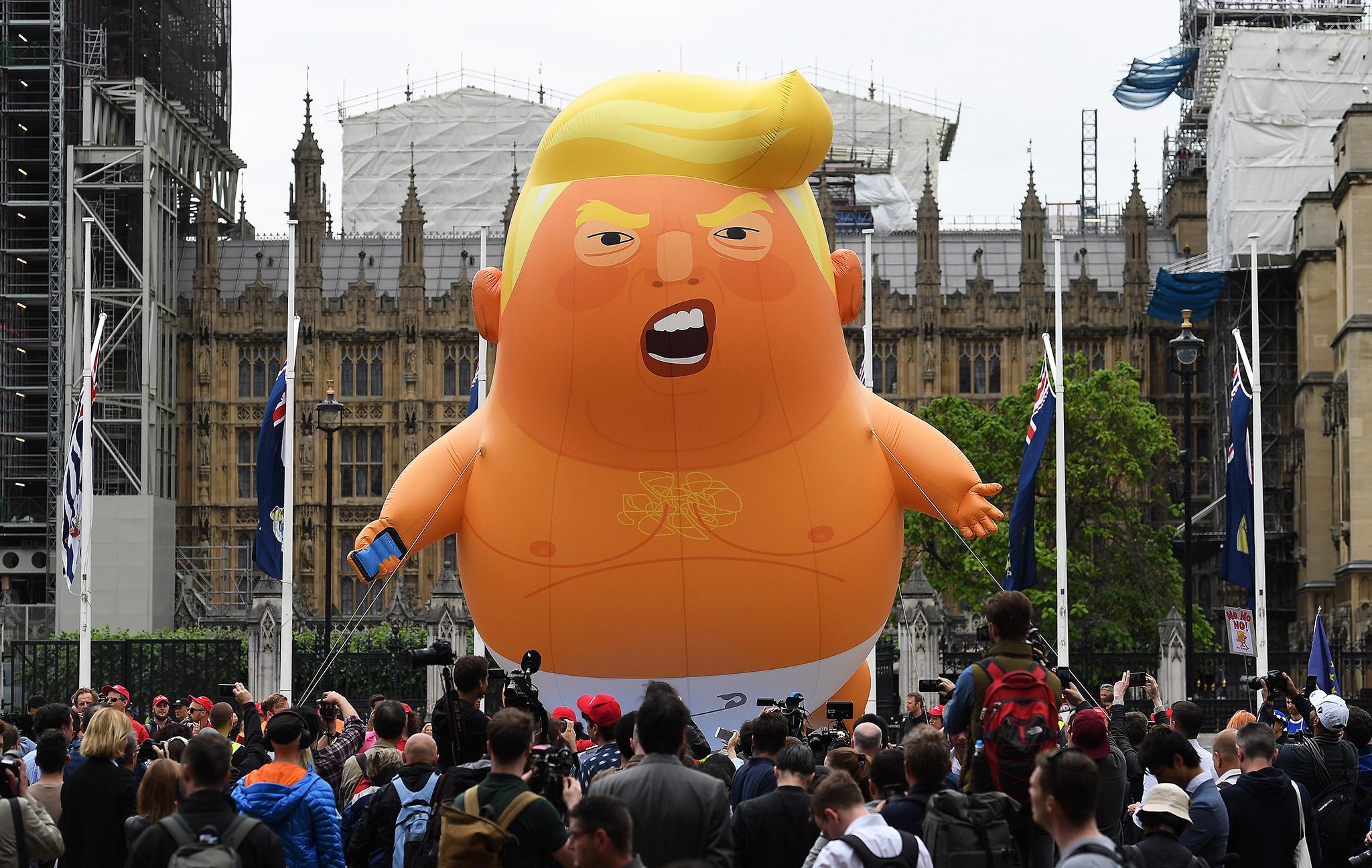 Anti-Trump protesters with a Trump baby blimp flying over Parliament Square gather for a protest against Donald Trump’s state visit to the UK in 2019